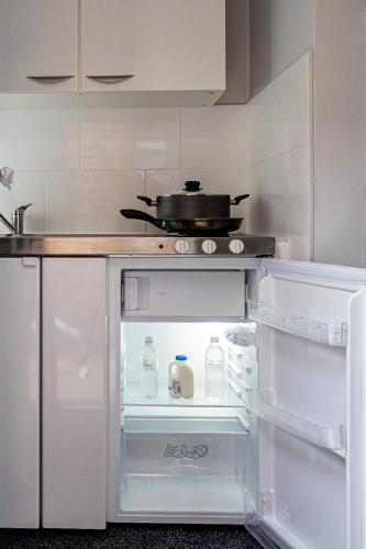 a kitchen with an open refrigerator with a pot on top at Modern and Stylish 1-Bedroom Guesthouse near M6 J10 Perfect for Business Stays & Couples Free Parking & Wi-Fi in Willenhall