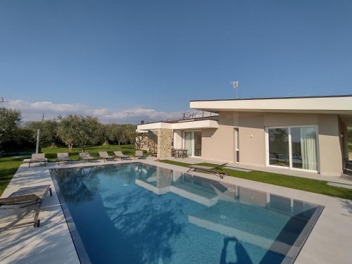 uma grande piscina em frente a uma casa em La Rondinella Apartments em Bardolino