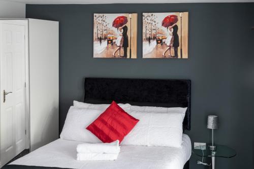 um quarto com uma cama com duas pinturas na parede em Luxury one bedroom guesthouse M6, Junction 10 Walsall em Willenhall
