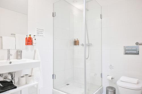 a white bathroom with a shower and a sink at UMA Santa Catarina - Pool & Fitness, Adults Only in Porto