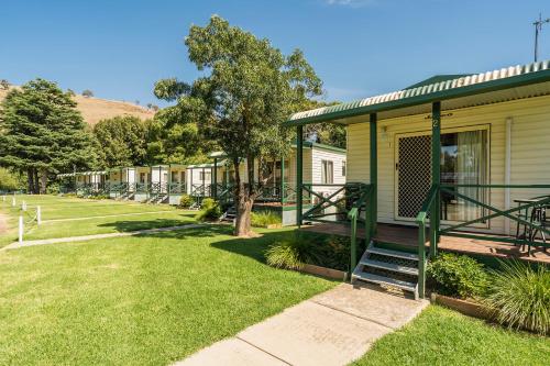 a house with a fence and a porch at Gundagai Cabins & Tourist Park in Gundagai