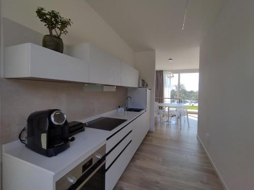 a white kitchen with a sink and a counter at La Rondinella Apartments in Bardolino