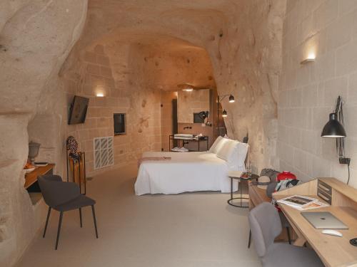 um quarto com uma cama num quarto de pedra em Palazzo Degli Abati em Matera