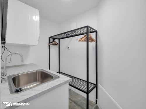 a kitchen with a sink and a metal shelf at Stepping Stone in Thredbo
