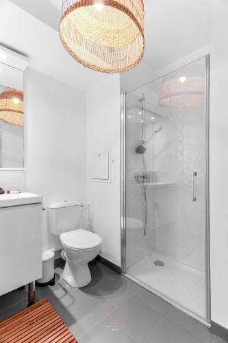 La salle de bains est pourvue d'une douche, de toilettes et d'un lustre. dans l'établissement *DISNEYLAND-SERRIS* Studio Cosy, à Serris