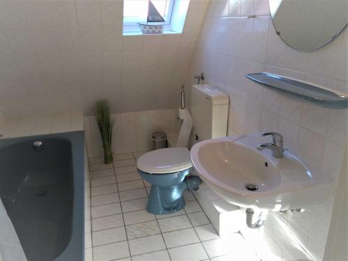 a bathroom with a toilet and a sink at Bahnhofsweg 12 in Sierksdorf