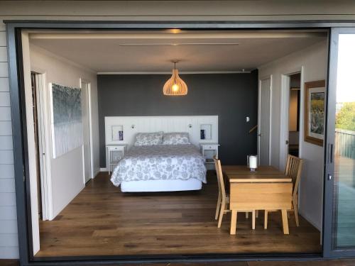 a bedroom with a bed and a table and a dining room at Studio or Cabin on Whitby in Nelson