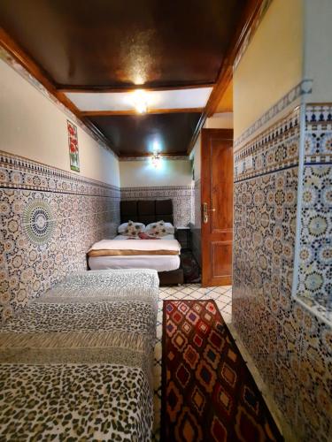 a bedroom with a bed in a room with tiles at Riad 112 in Marrakesh