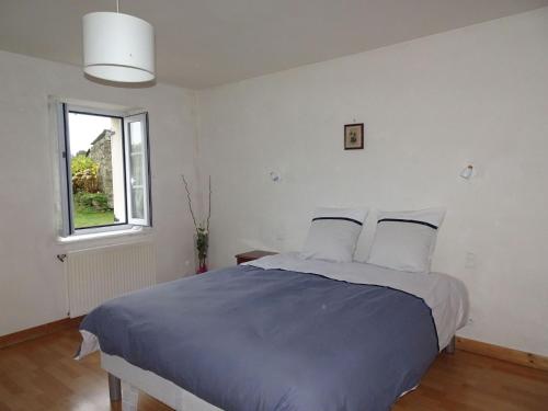 une chambre blanche avec un grand lit avec des oreillers dans l'établissement Stone House in Treboul near Pointe du Raz, à Douarnenez