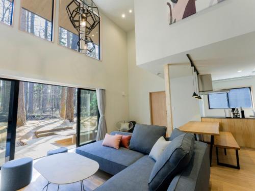 a living room with a blue couch and a table at Rakuten STAY VILLA Fuji Kawaguchiko Forest 2LDK with sauna and terrace in Fujikawaguchiko