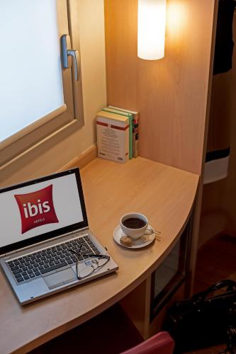 a laptop computer sitting on a table with a cup of coffee at ibis Ankara Airport Hotel in Ankara