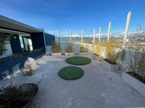 a patio with grass and plants on the side of a building at Bambu-Rivera Club Residences in San José