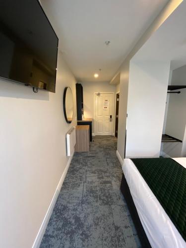 a corridor of a room with a bed and a mirror at Trinity Hotel in Wellington