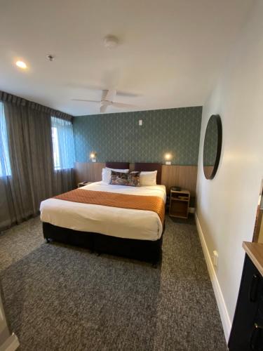 a hotel room with a large bed and a mirror at Trinity Hotel in Wellington