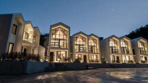 un grand bâtiment avec beaucoup de fenêtres la nuit dans l'établissement Albescent Poolvilla, à Gyeongju