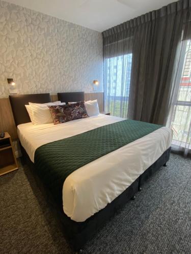 a large bed in a room with a large window at Trinity Hotel in Wellington