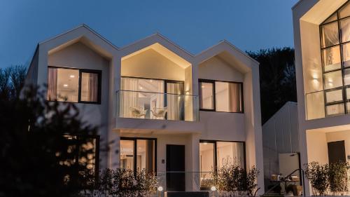 un grand bâtiment blanc avec des fenêtres au crépuscule dans l'établissement Albescent Poolvilla, à Gyeongju