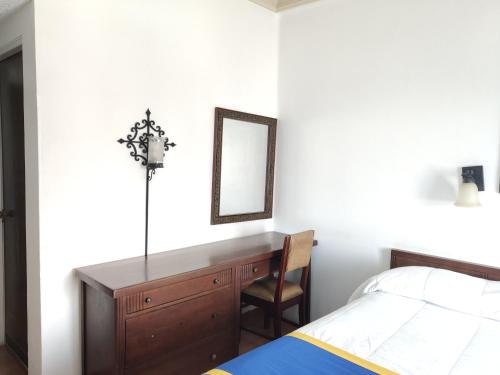 a bedroom with a desk and a bed and a mirror at Hotel Sierra Gorda in Ciudad Victoria