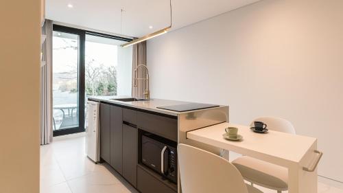 a kitchen with a counter and a table and chairs at Albescent Poolvilla in Gyeongju