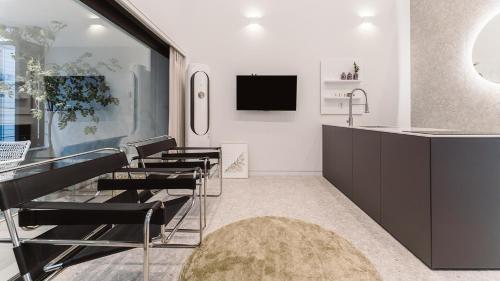 a kitchen with chairs and a sink and a tv at Albescent Poolvilla in Gyeongju