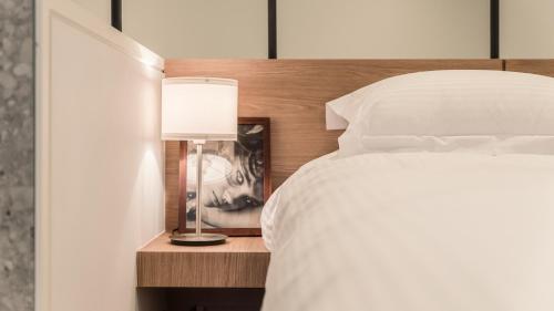 a bedroom with a bed and a lamp on a night stand at Albescent Poolvilla in Gyeongju