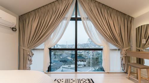 a bedroom with a large window with a view at Albescent Poolvilla in Gyeongju