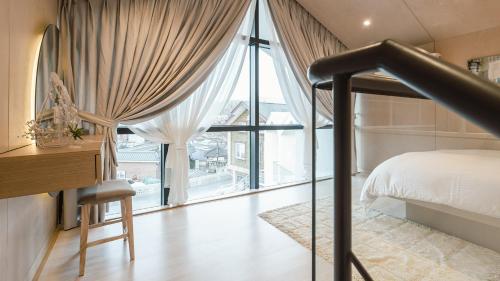 a bedroom with a bed and a large window at Albescent Poolvilla in Gyeongju