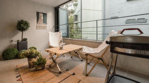 a small balcony with a table and a grill at Albescent Poolvilla in Gyeongju