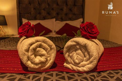 two towels with roses on top of a bed at Rumi's Inn in Cusco