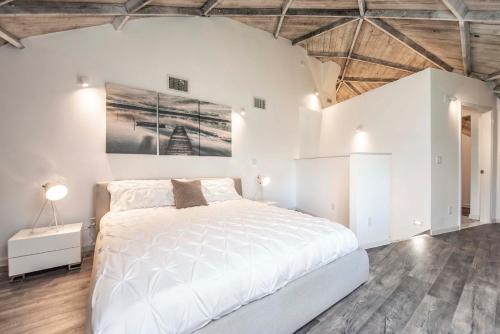 a white bedroom with a bed and a painting on the wall at Sumner Lake House 2B in Clermont