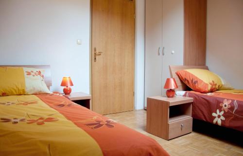 a bedroom with two beds and a night stand with two lamps at Apartments Lipa in Železniki