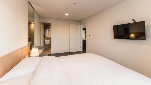 a bedroom with a bed and a television on the wall at Albescent Poolvilla in Gyeongju