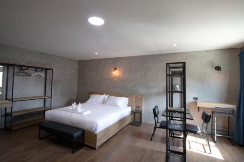 1 dormitorio con cama, escritorio y escalera en Rabbit Hotel Phimai en Pi Mai