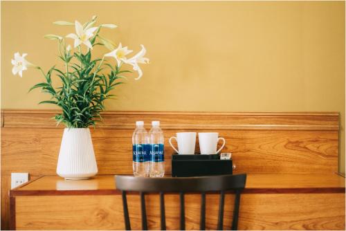 a table with two bottles of water and a vase at Ninh Binh The View Point Home & Spa in Ninh Binh
