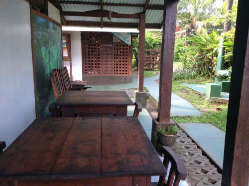 an old wooden table and chairs on a patio at Cabinas Balcon del Mar Tortuguero in Tortuguero