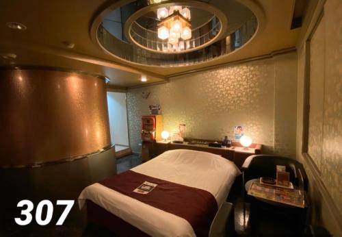 Habitación de hotel con cama y espejo en ホテルレスポアール, en Minatomachi