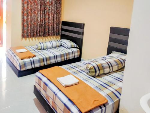 - deux lits assis l'un à côté de l'autre dans une pièce dans l'établissement RedDoorz @ Makarios Hotel Poso, à Poso