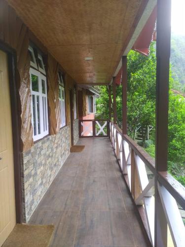 a corridor of a building with a wooden walkway at Odyssey Stays Rimbi in Pelling