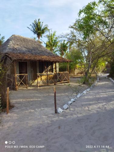 a small building with a straw roof on a beach at Room in BB - Mida Creek Eco Camp 1 