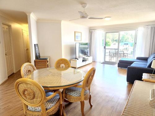 a living room with a dining room table and chairs at Fairways Golf & Beach Retreat Bribie Island in Woorim