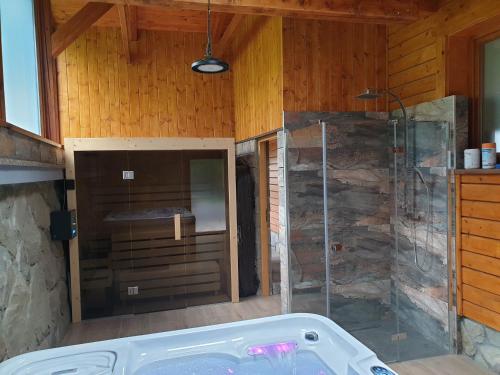Das Bad ist mit einer Badewanne und einer Glasdusche ausgestattet. in der Unterkunft Chata Aneta in Námestovo