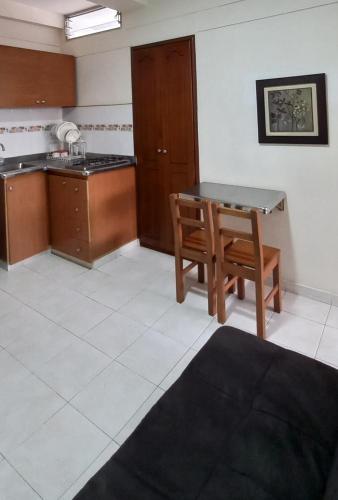 a kitchen with a table and a wooden chair at San Juan Del Lago in Pereira