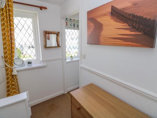a room with a table and a painting on the wall at Grooms Cottage in Tenby
