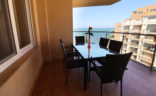 a dining room with a table and chairs and a balcony at Galerius Golden Beach Apartment in Siófok