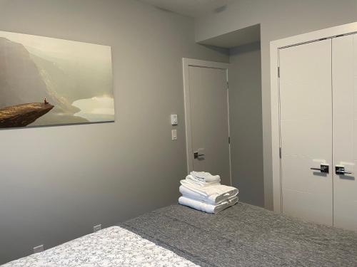 a bedroom with a bed with a stack of towels at Hamm Suite in Saskatoon