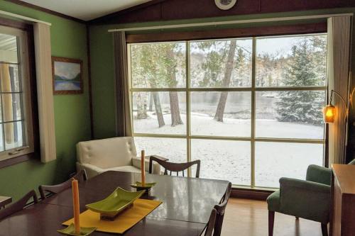 a dining room with a table and a large window at Whole home, private lake, sauna, WFH office in Michigamme