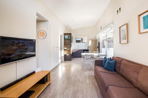 a living room with a couch and a flat screen tv at Smiths Beach Resort in Yallingup