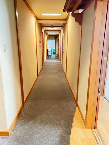 an empty corridor in an office building with a long hallway at Ryokan Kousen Kazeya Group in Nara