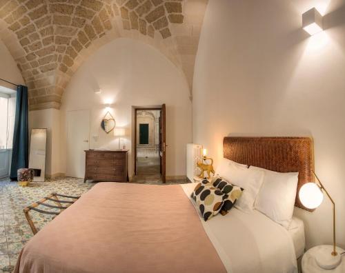 een slaapkamer met een groot bed en een badkamer bij FORLEO Historic Apartments - TREB Collection in Lecce