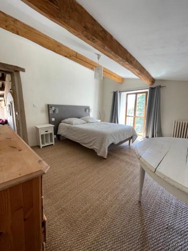 ein Schlafzimmer mit einem Bett und einem großen Fenster in der Unterkunft La Maison de Vergol in Montbrun-les-Bains